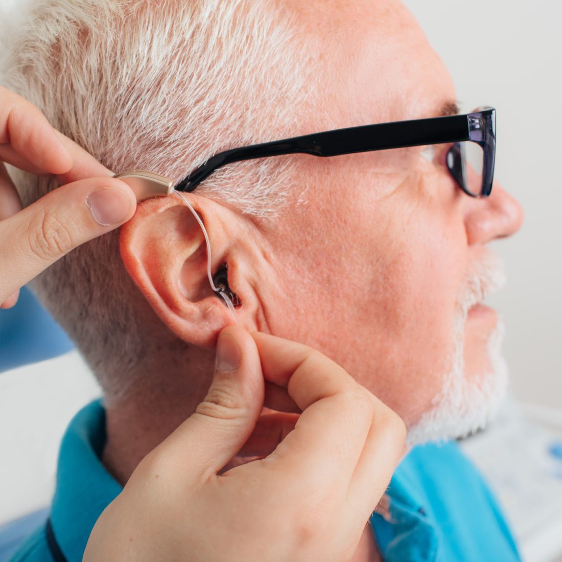 patient is assisted in setting up the hearing aid. Treatment of hearing of elderly people using a hearing aid.